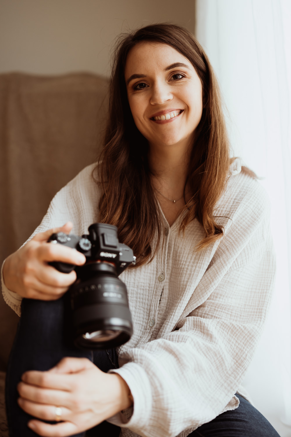 Das Bild zeigt die Familienfotografin Christina Weitze mit einer Kamera in Hand.
